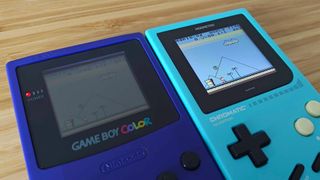 Modretro Chromatic next to original purple Game Boy Color with both running Super Mario Land