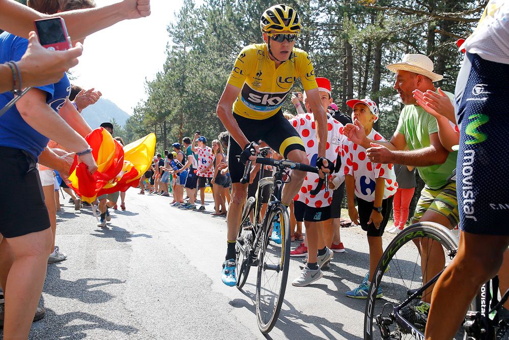 Chris Froome climbs through a gauntlet of spectators during stage 14.