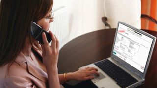 Woman using phone and laptop