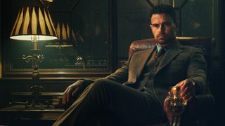 Theo James as Edward "Eddie" Horniman sitting on a fancy chair during season 1 of the Netflix show, The Gentlemen.