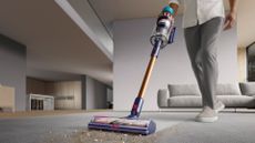 A person running a Dyson Gen5outsize cordless vacuum cleaner over a dry spill