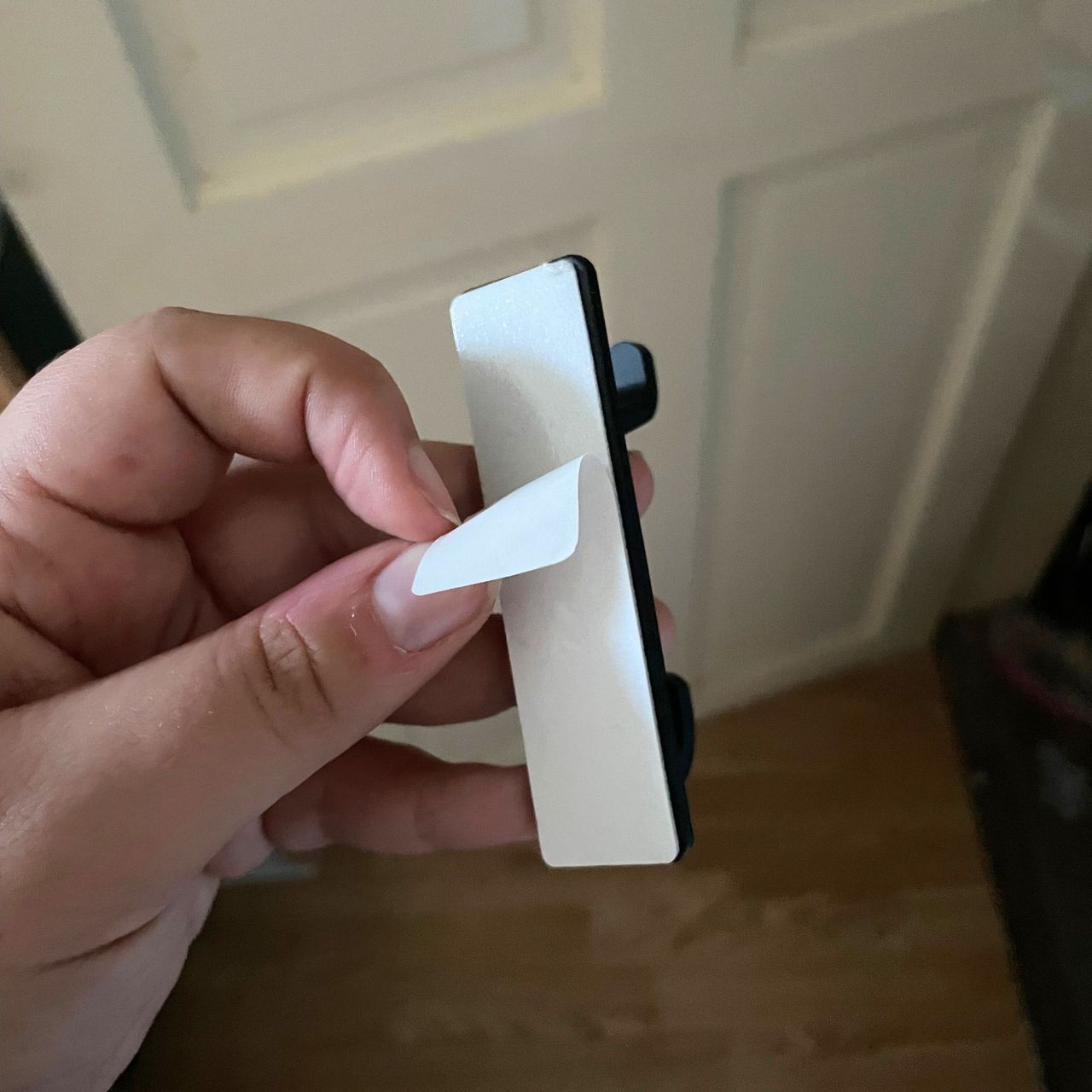 Peeling the paper off self-adhesive hooks