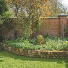 Brick garden edging between border and lawn in garden