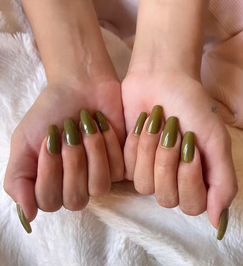 Two hands showing an olive green manicure, long squoval tips
