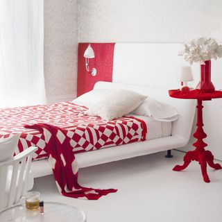 bedroom with red and white bedding set and white walls