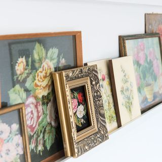 room with white wall and vintage photoframes