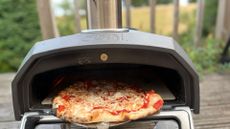 Pulling a pizza out of the Ooni Karu 12 2nd Generation