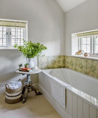 white themed bathroom with window side bathtub