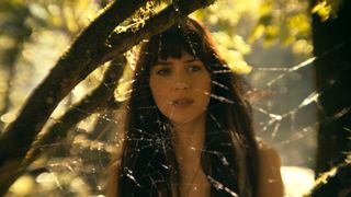 Cassandra Webb stands in front of a spider web in the Madame Web movie