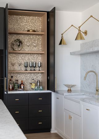 a large drink cabinet with four shelves and wine glasses. There are also drinks on the shelves.