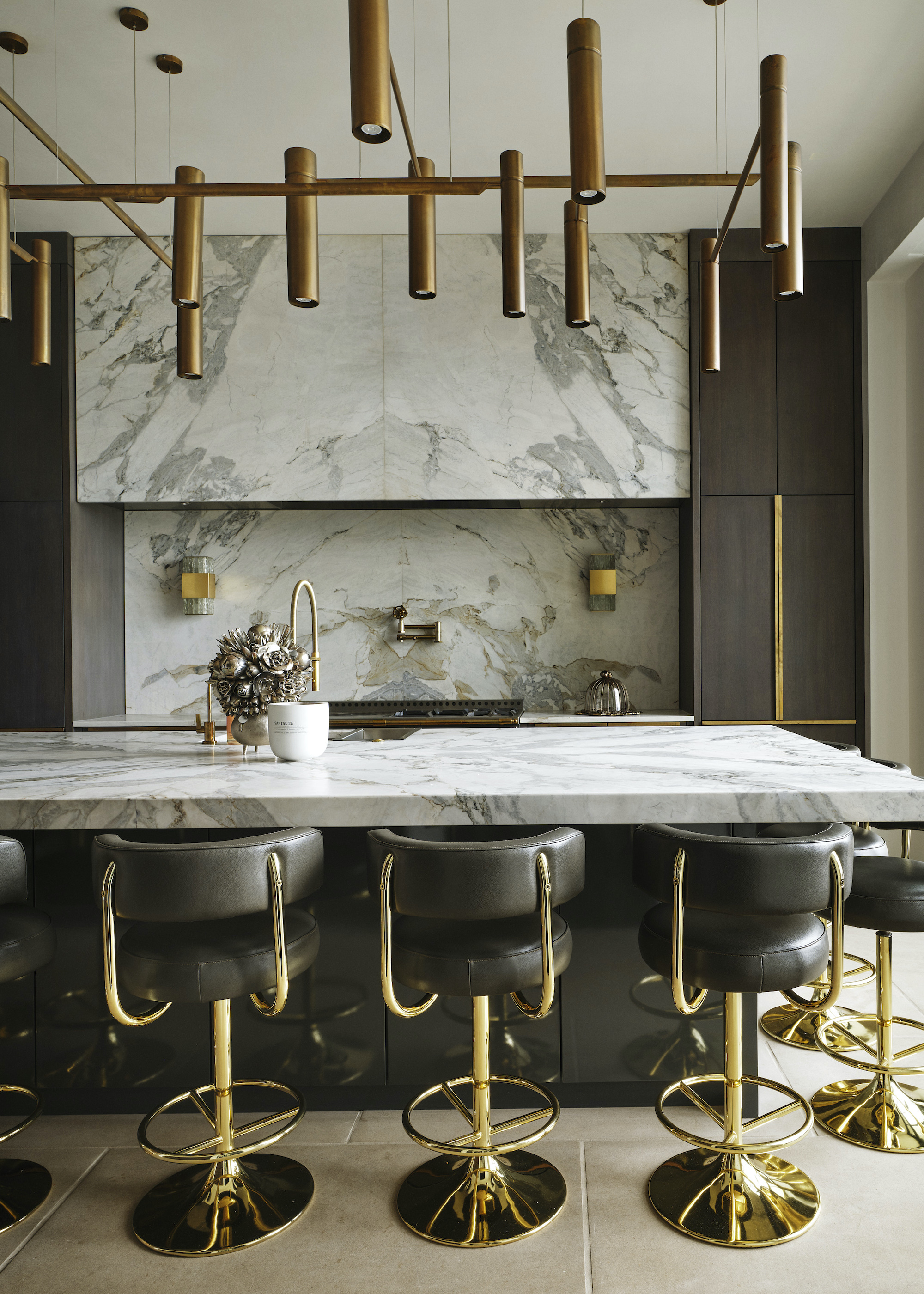 marble and wood kitchen with brass and leather bar stools