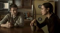 a husband and wife sit at a kitchen table