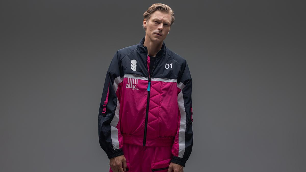 A blond male model wears the tracksuit top from The Alters.