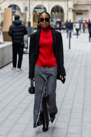 A woman in a red jumper and grey denim maxi skirt GettyImages-2016373908