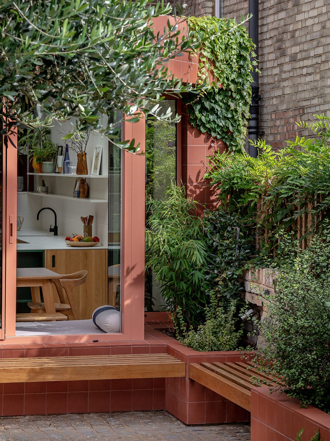 terracotta tiled extension with built-in outdoor bench seat and connecting window