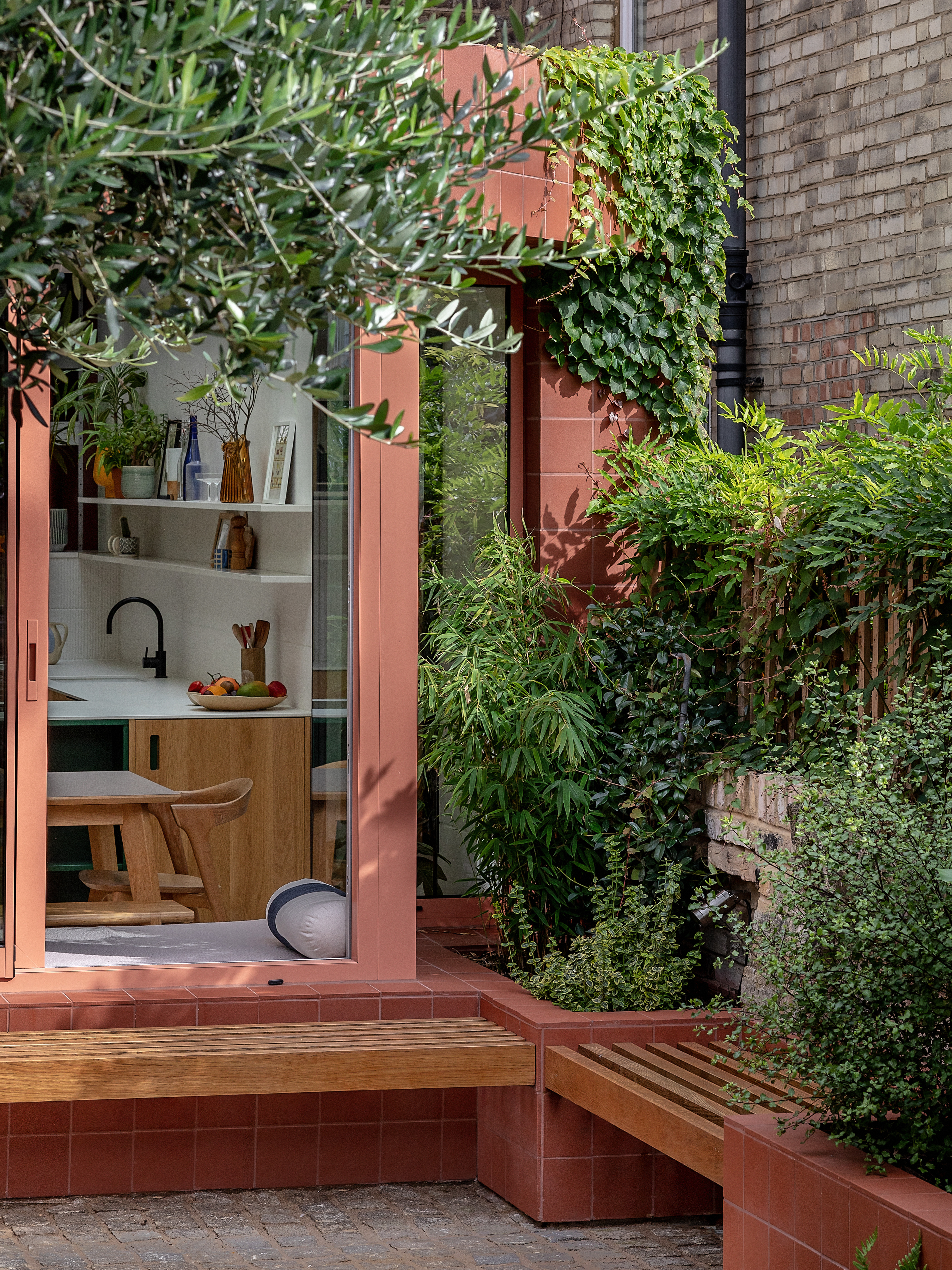 terracotta tiled extension with built-in outdoor bench seat and connecting window