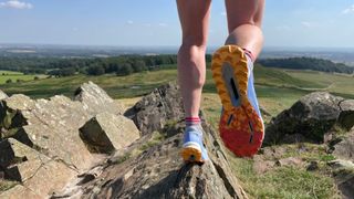 Woman wearing Adidas Terrex Agravic Ultra trail running shoes on a ridge