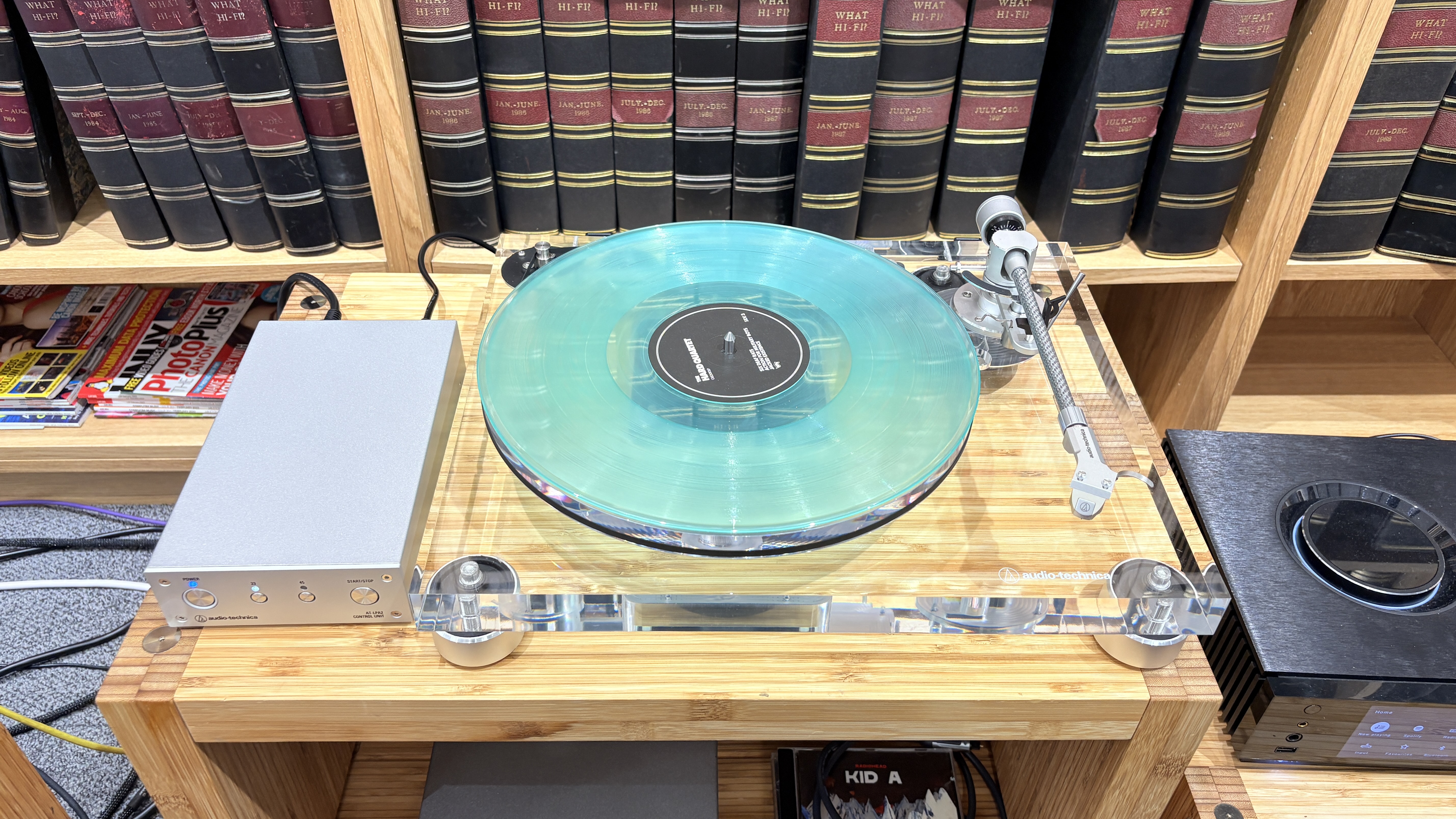 Audio-Technica AT-LPA2 turntable on wooden rack with books in background