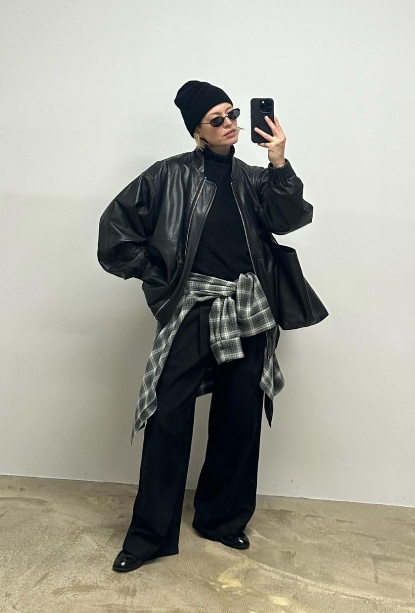 alexis foreman wears an all black outfit with a check shirt tied around her waist