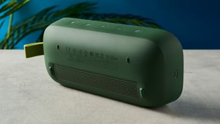 a green bluetooth speaker made by bose with a clean plastic casing and no visible woofers rests on a table