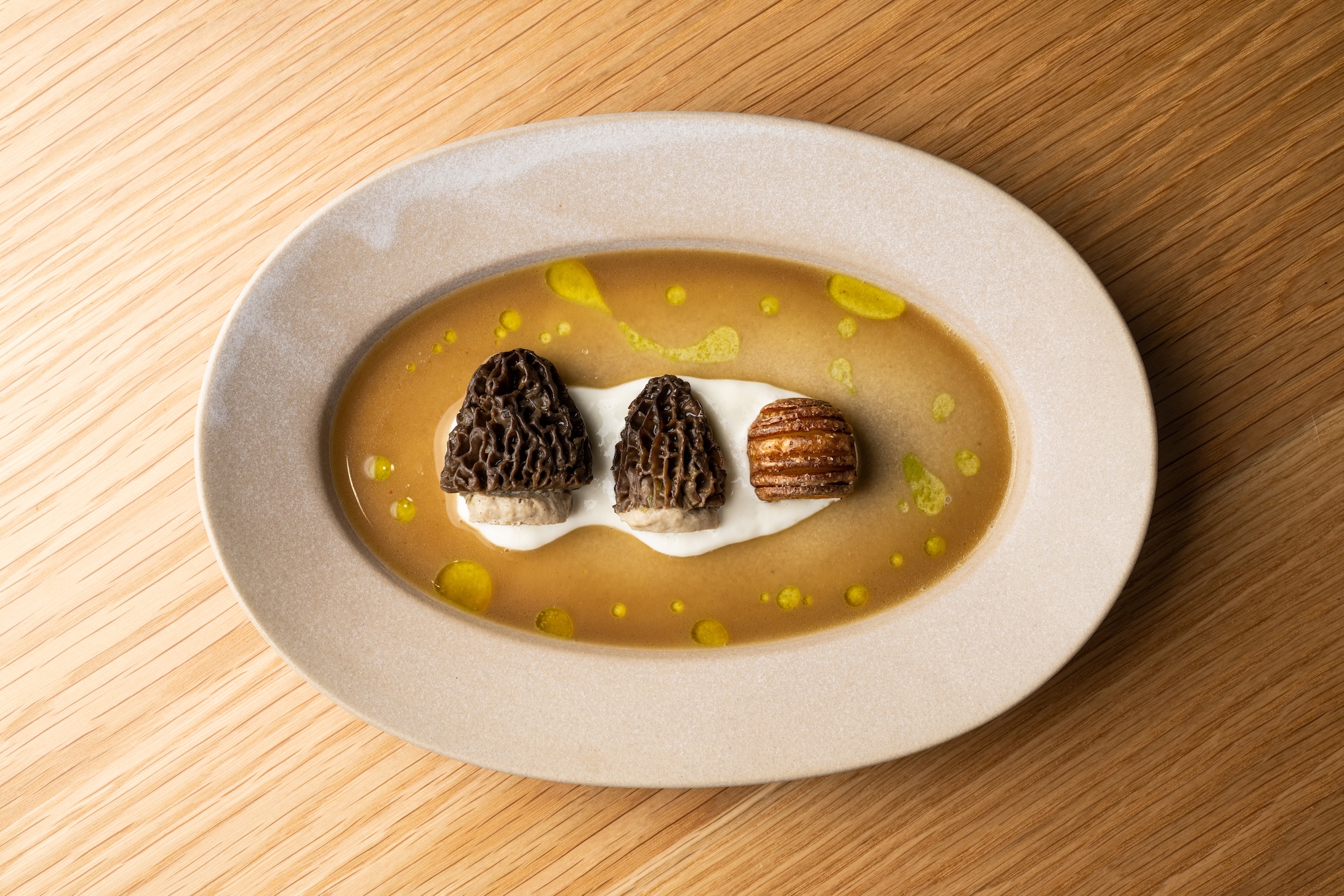 a dish from jacaranda los angeles with three mushrooms in broth