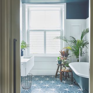 blue and white bathroom with cafe style shutters
