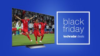 An LG C2 TV showing football players celebrating, with a sign saying Black Friday deals