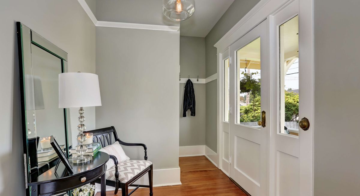 Light and bright entryway with a console table, pendant light , mirror and chair