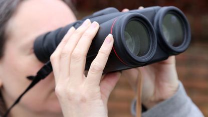 Woman holding a pair of Canon 10x42L IS WP binoculars