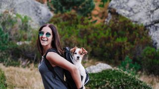 Woman carrying dog in backpack