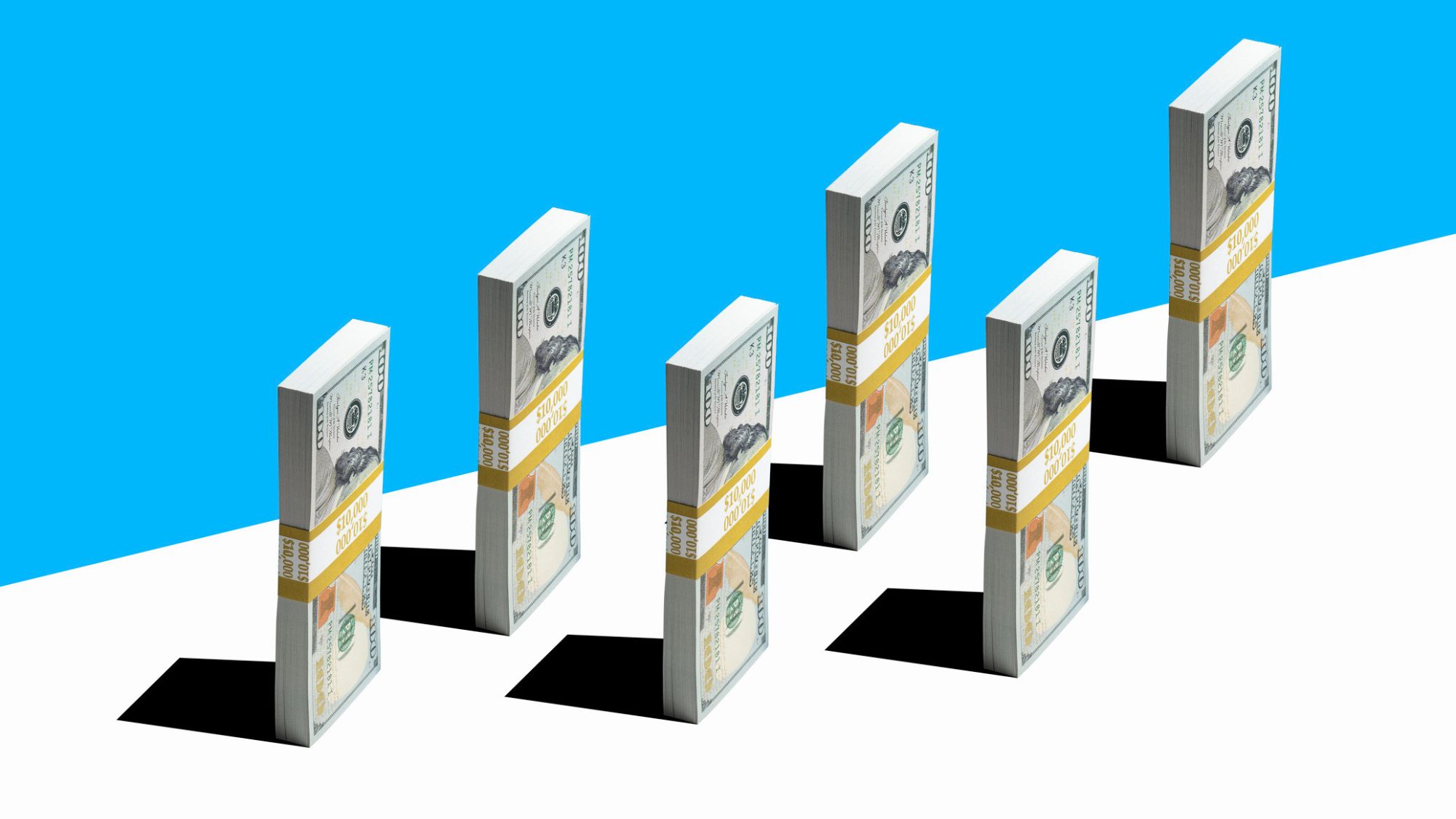 Bundles of US currency standing against a blue and white background