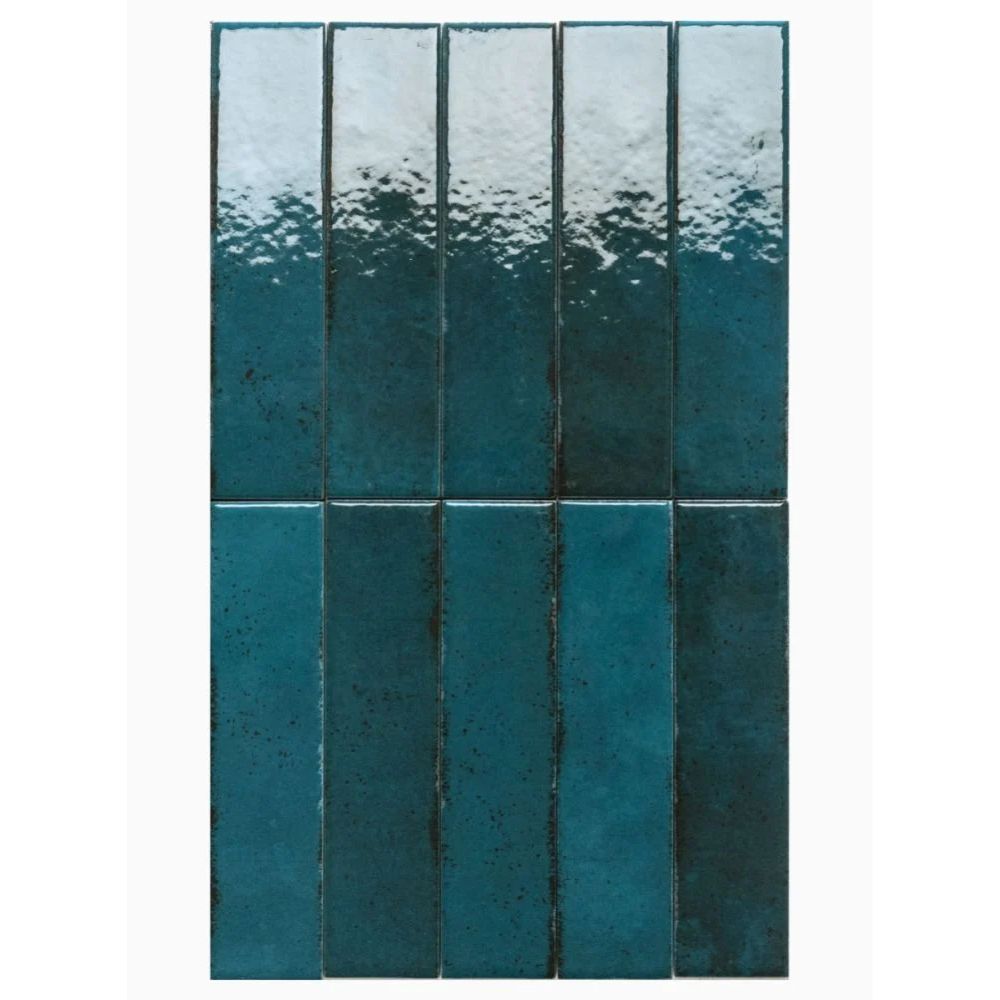 A close-up of deep teal glazed ceramic tiles in a vertical brick pattern, showing a mottled, handmade-effect glaze fading from pale blue-white at the top to rich teal below
