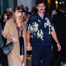 Taylor Swift and Travis Kelce leaving a restaurant in New York City where Taylor Swift wears a camel coat and a lace corset by gucci