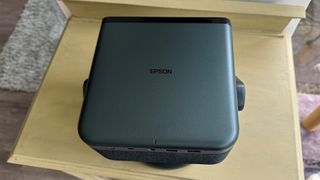 Epson EF-22 portable projector on wooden table top-down view