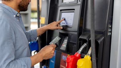 Close-up on a man paying by credit card at a gas station