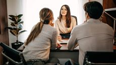 Couple sitting a desk talking to a female lawyer 