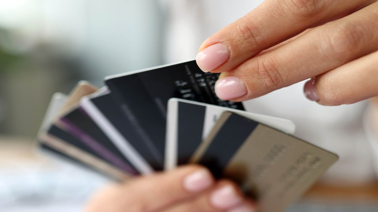 Hand choosing a credit card from many offered.