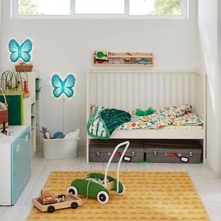 girls nursery with white walls cot and blue butterfly lights