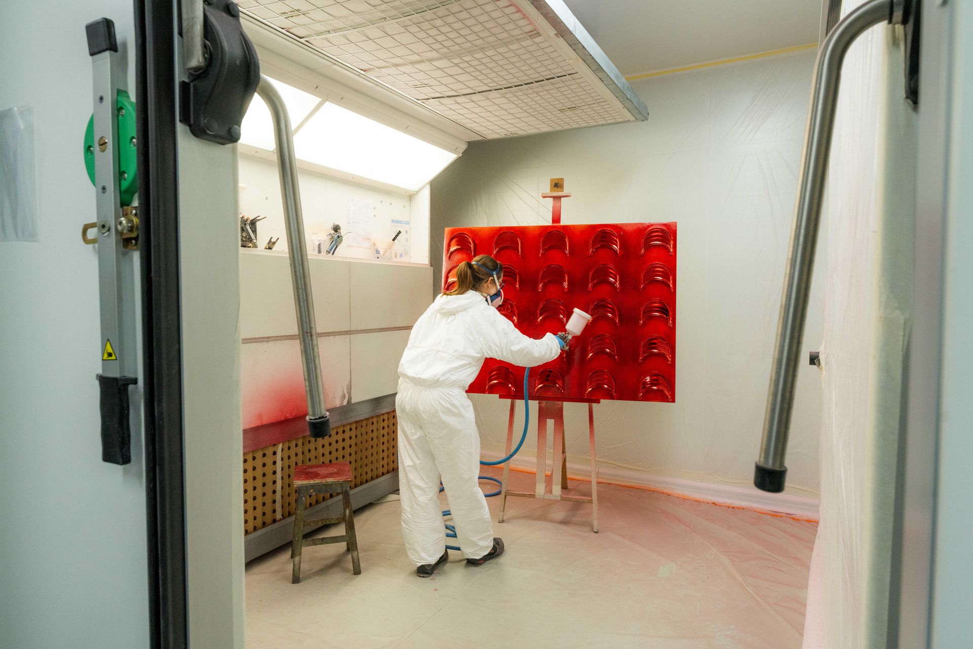 Artisan applies lacquer to board of speaker parts