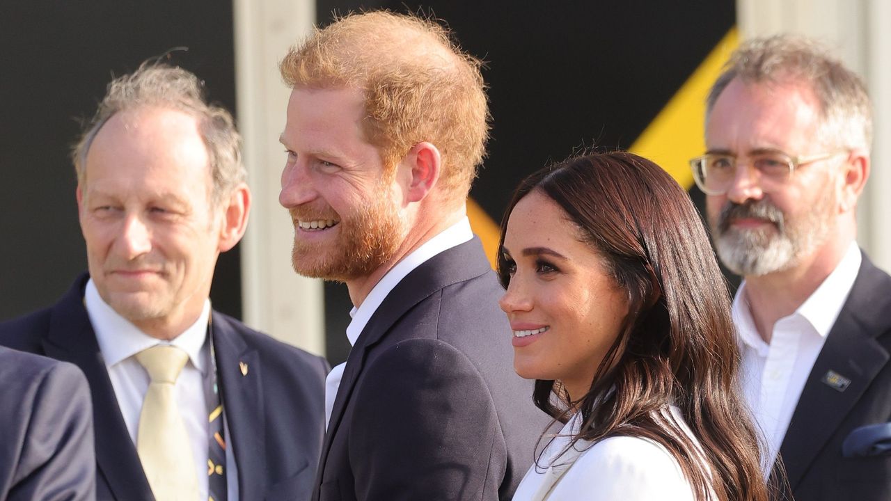 Prince Harry and Meghan Markle smile outside