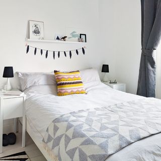 bedroom with yellow cushion and white wall