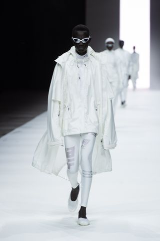 Model on runway wearing white sporty outfit