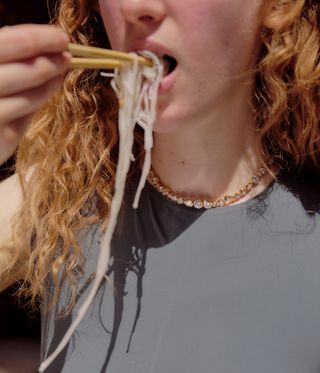 woman eating noodles, wearing necklace by Completedworks