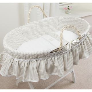 white wall with curtain and moses basket with stand