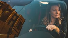 A woman test-drives a car.