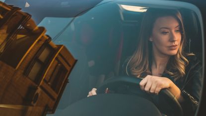 A woman test-drives a car.