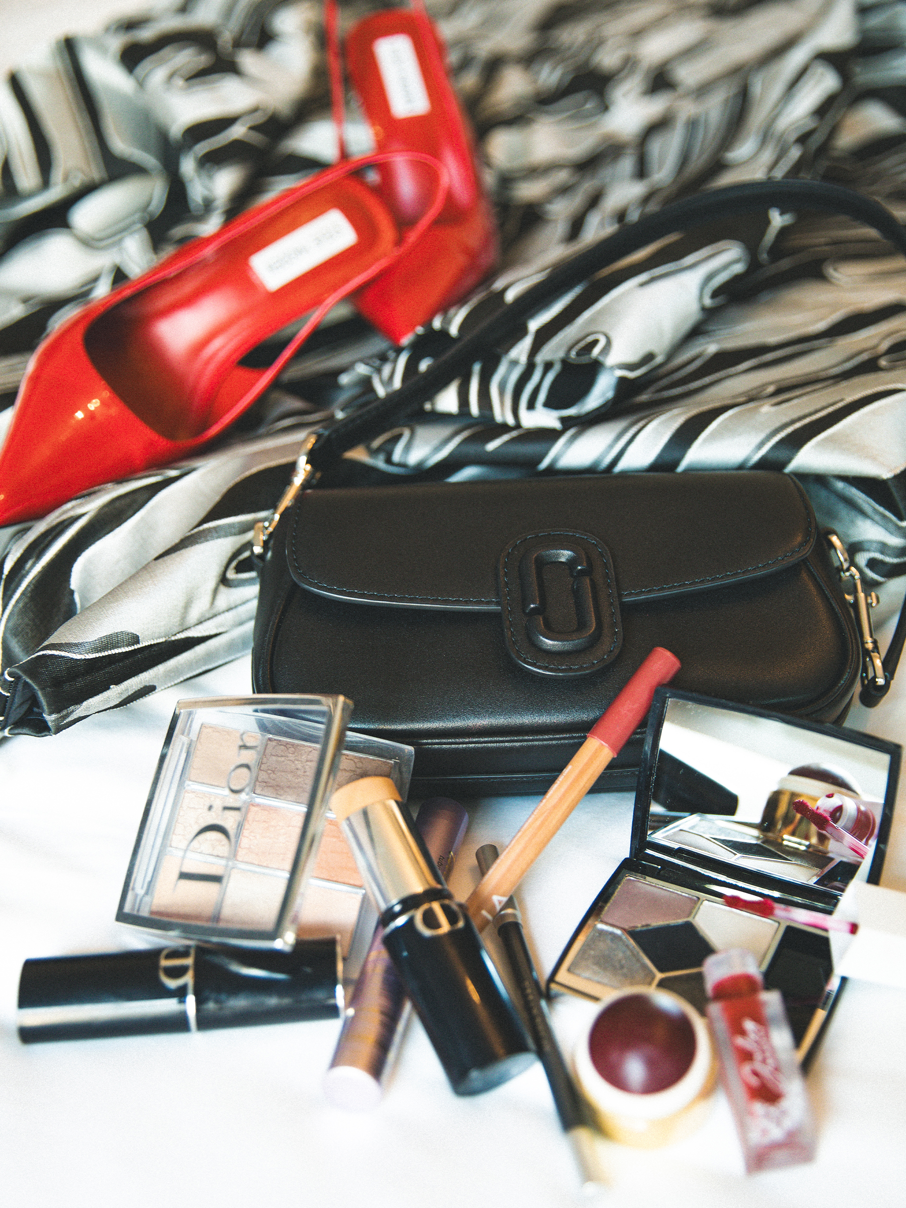 Anna Lambe's accessories for the Gotham TV Awards, featuring red slingback heels, a black shoulder bag, and Dior makeup.
