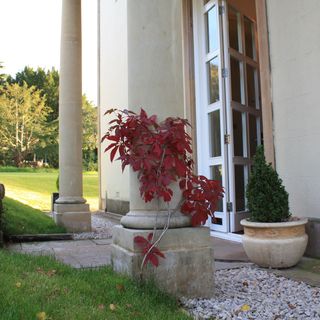 pillars at entrance of house white door and plants