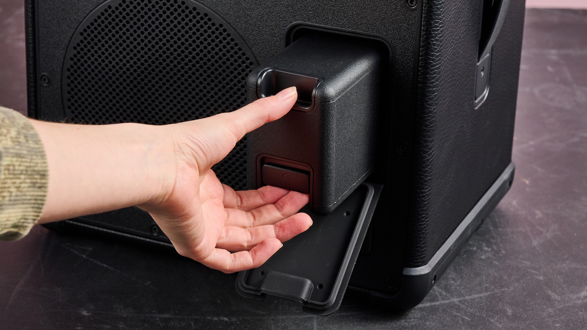 Person taking battery out of the Marshall Bromley 450