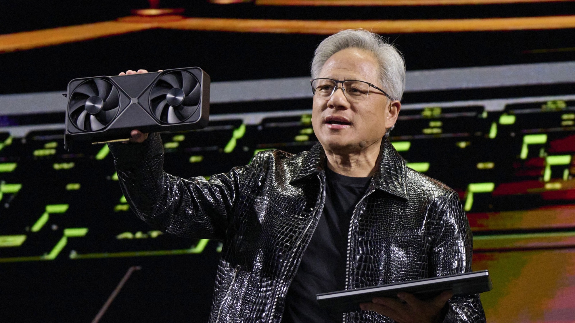 Jensen Huang, co-founder and chief executive officer of Nvidia Corp., speaks while holding one of the company's new GeForce RTX 50 series graphics cards during the 2025 CES event in Las Vegas, Nevada